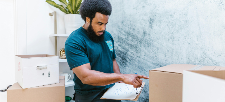 Mover with a clipboard checking boxes, showing the efficiency of senior movers Boston elders respect.