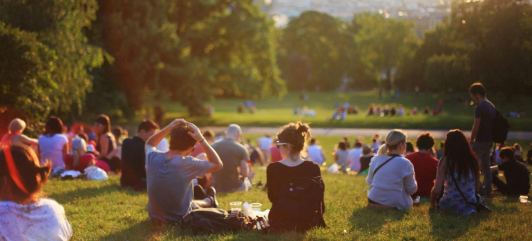 People relaxing in a sunny park, showing that spring is a great time to plan your move.