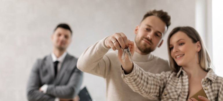 A Couple Holding Their Keys after moving to one of The most Popular MA Cities People Are Moving to This Year