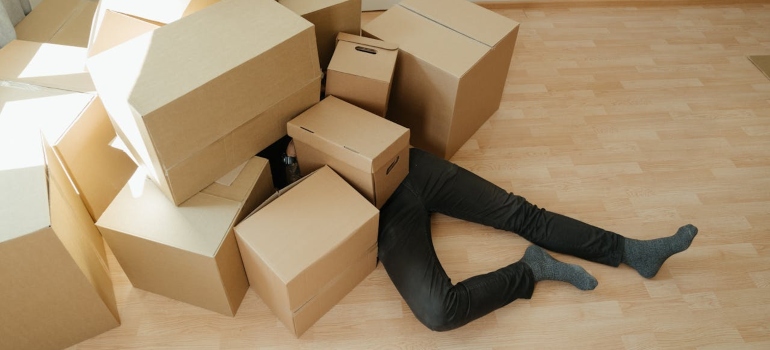 a man lying on the floor with boxes over him