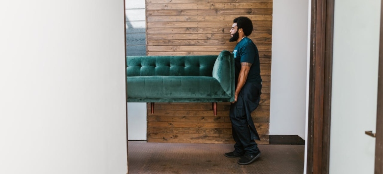 a man carrying a sofa