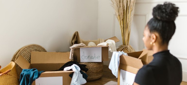 A Woman Sitting in front of Cardboard Boxes

